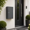 Anthracite grey small wall mounted parcel box installed beside a modern residential entrance for secure home delivery
